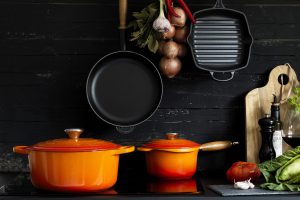 zwei orangenen Kochtöpfe von Le creuset stehen auf Kochplatte